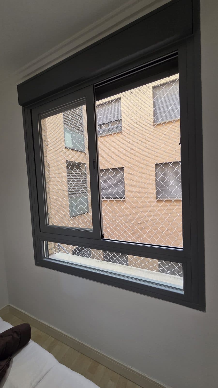 Red de seguridad instalada en una ventana corredera