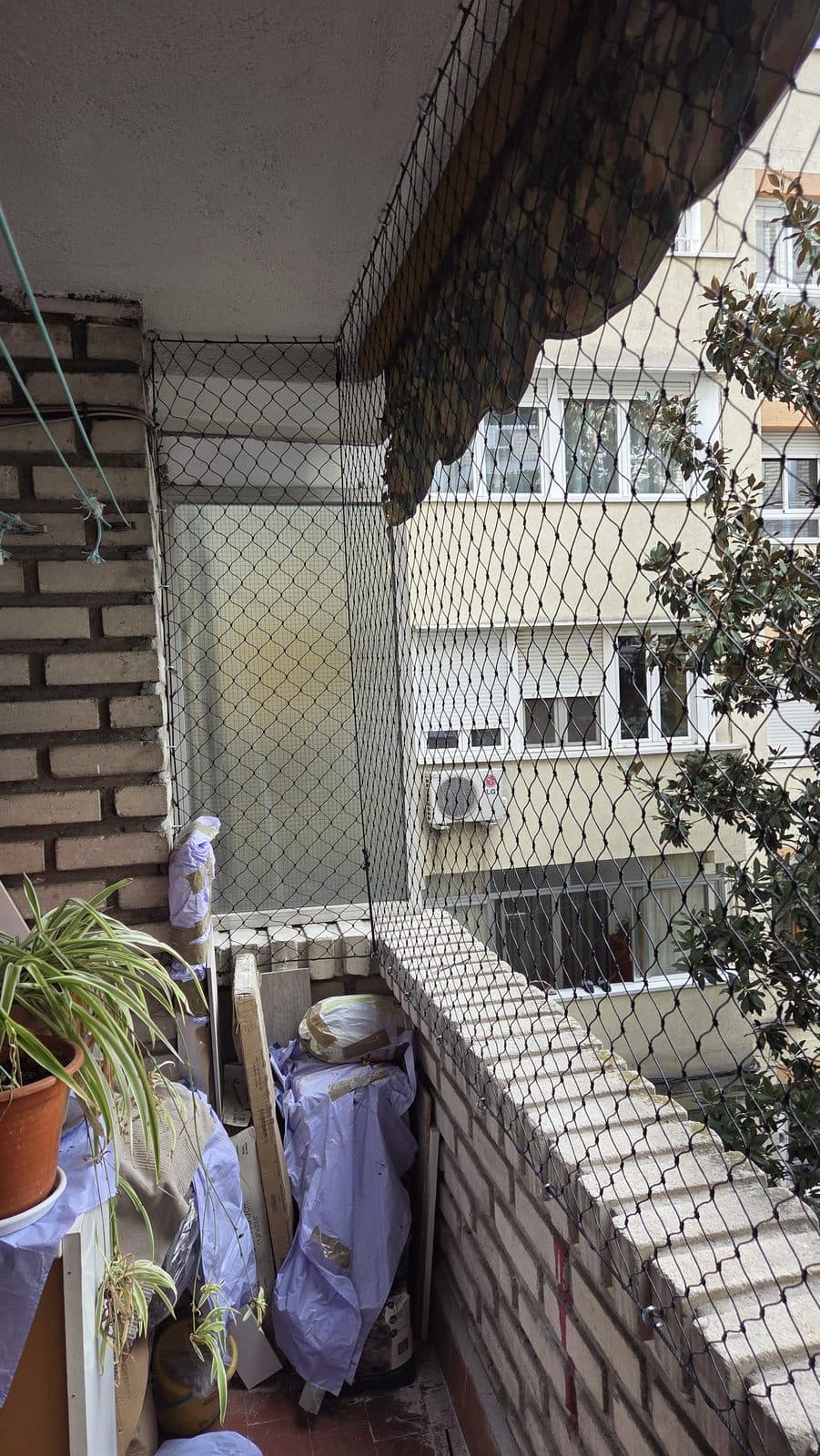 Balcón de ladrillo visto con red de protección