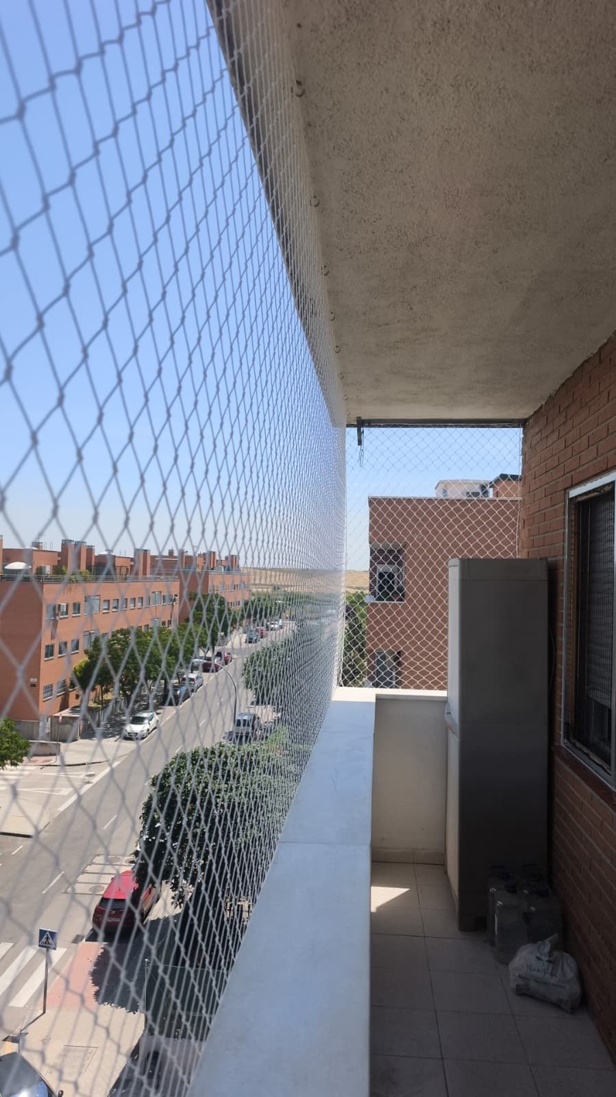 Balcón lateral con red de seguridad y vistas a la calle